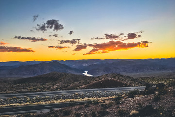 Unlimited View On Mountains With Sunset In Arizona With Orange Sky And Rover Between Rocks