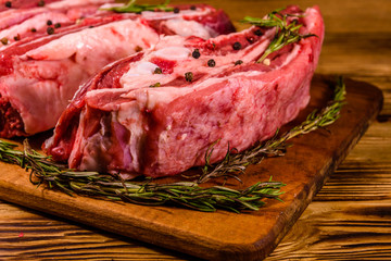 Raw pork ribs with spices and rosemary on a cutting board