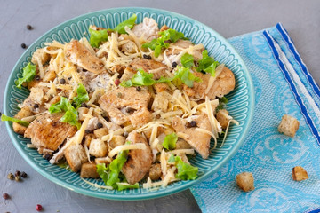 Delicious salad with chicken and crackers on a plate. Caesar salad.
