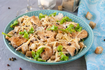 Delicious salad with chicken and crackers on a plate. Caesar salad.