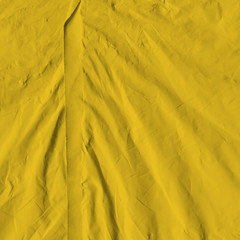 Transparent yellow plastic wrap on the black background. Plastic shopping bag texture. Reusable trash and waste.