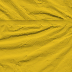 Transparent yellow plastic wrap on the black background. Plastic shopping bag texture. Reusable trash and waste.