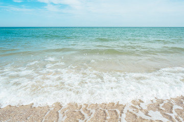 Blue turquoise sea waves with sand and sky clouds