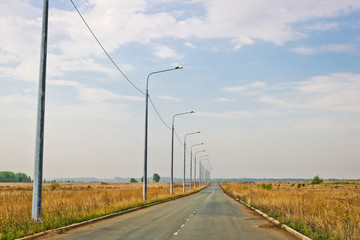 Asphalt road and lighting lights on the side of the road at the entrance to the city.