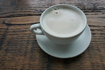 Chai Latte in a white cup on a wooden table