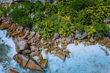 Aerial drone photo of stony boulders of beautiful Anse Cocos beach at La Digue, Seychelles