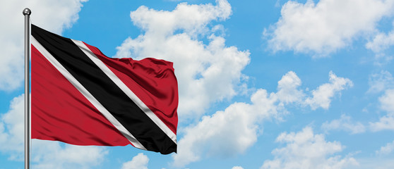 Trinidad And Tobago flag waving in the wind against white cloudy blue sky. Diplomacy concept, international relations.