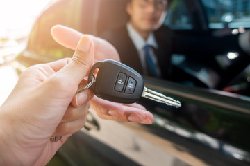 Business man  is holding key car in the car