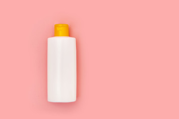 blank white squeeze bottle plastic tube on pink background copy space