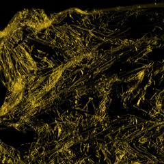 Transparent yellow plastic wrap on the black background. Plastic shopping bag texture. Reusable trash and waste.