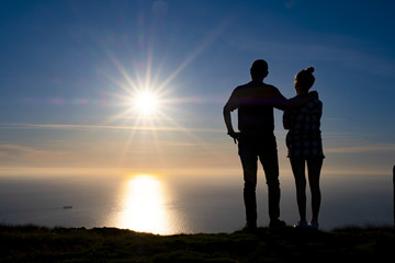 couple with the sea and the sun at sunset
