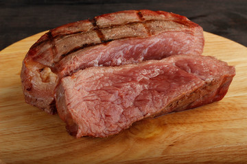 steaks of beef on wooden background