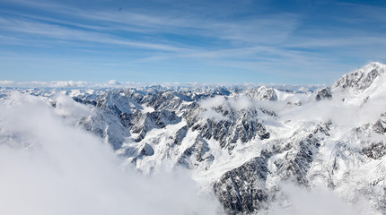 Fototapeta na wymiar Panoramic view from a high point on the snow-covered mountain range. Mountain Altai.