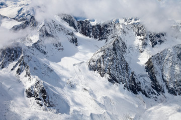 View from a high point on the snow-capped mountain couloirs and rocks