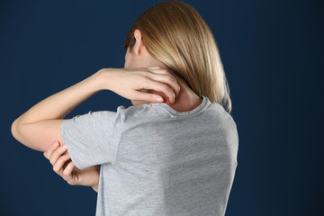 Woman scratching neck on color background. Allergy symptom