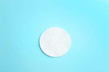 Cotton pad on color background, top view