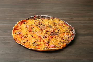 Tasty black and white pizza on wooden table