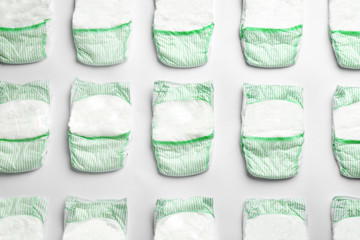 Flat lay composition with diapers on white background. Baby accessories