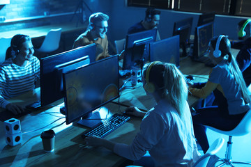 Group of people playing video games in internet cafe