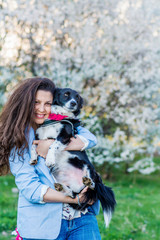 Naklejka na ściany i meble Beautiful Smiling Woman Hugging Her Cute Dog in a Spring Garden .Pet and Owner Outdoor in the Spring