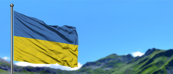 Ukraine flag waving in the blue sky with green fields at mountain peak background. Nature theme.