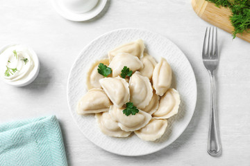 Flat lay composition with tasty dumplings served on white table