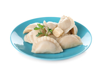 Plate of tasty dumplings served with parsley and butter on white background