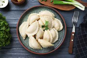 Flat lay composition with tasty dumplings served on wooden table
