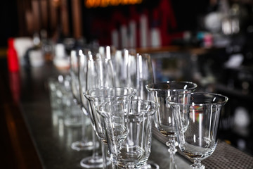Different empty clean glasses on counter in bar