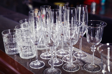 Different empty clean glasses on counter in bar