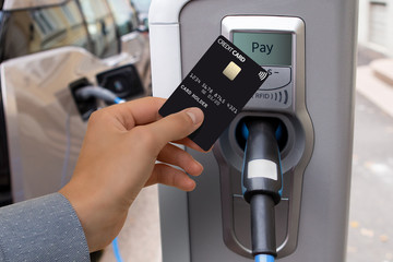 A man pays for charging an electric car.