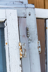dismantled old wooden windows closeup are made up in a row near the house. white window frames