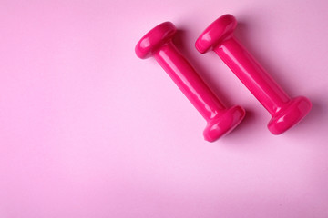 Bright dumbbells and space for text on color background, flat lay. Home fitness