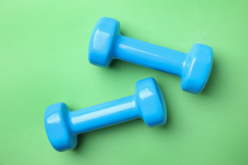 Bright dumbbells on color background, flat lay. Home fitness