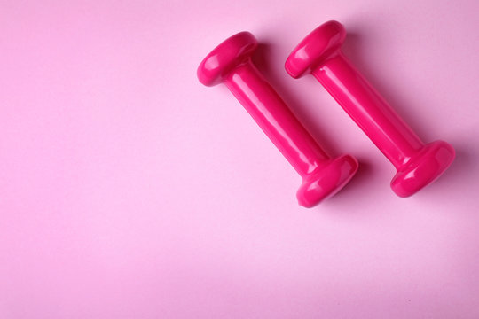 Bright dumbbells and space for text on color background, flat lay. Home fitness © New Africa