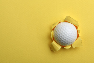 Torn color paper with golf ball, space for text. Sport equipment