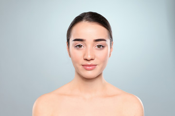 Portrait of young woman with beautiful face against color background