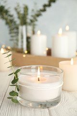 Burning aromatic candle and eucalyptus branch on table. Space for text © New Africa