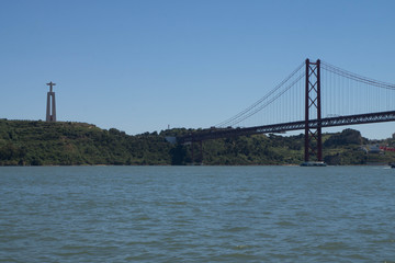 Vue du fleuve sur le pont du 25 avril de Lisbonne avec un ciel bleu