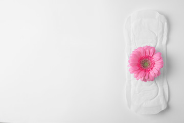 Fototapeta na wymiar Menstrual pad and flower on white background, top view with space for text. Gynecological care