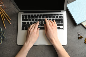 Woman using modern laptop at table, top view