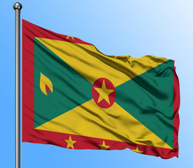 Grenada flag waving in the deep blue sky background. Isolated national flag. Macro view shot.