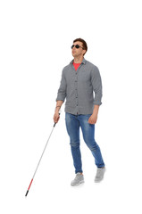 Young blind person with long cane walking on white background