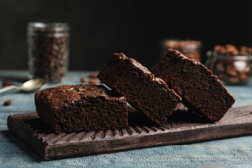 Wooden board with fresh brownies on table. Delicious chocolate pie