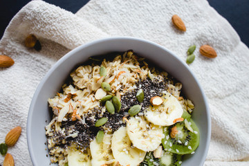 healthy Breakfast of oatmeal with fruit on a white napkin and almond