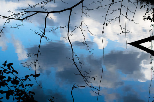 Clouds reflected in water in the Tiber river - Rome, Italy