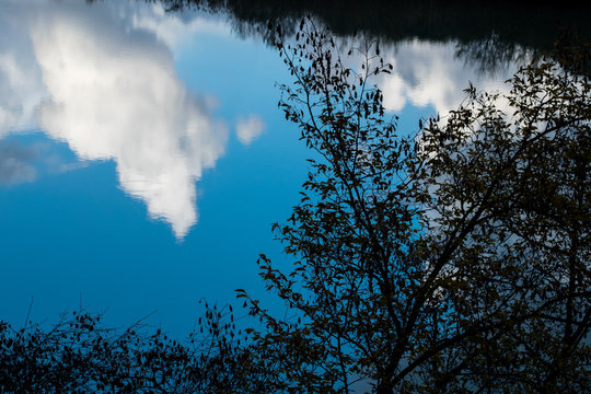 Clouds reflected in water in the Tiber river - Rome, Italy