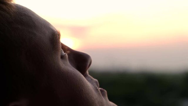 A man looking with hope into the sky, close up