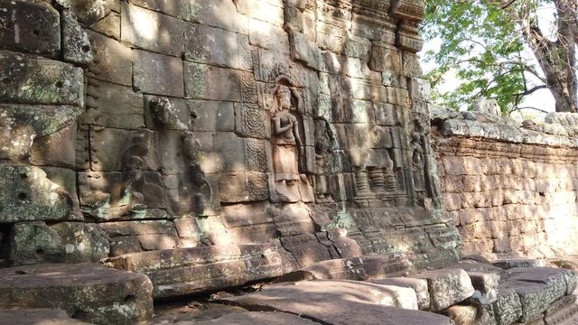 Divine dancer Apsara carved on a stone wall at the entrance of the temple TA Prom in Angkor Wat Cambodia. 