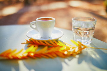 Cup of coffee on a table of traditional outdoor cafe in Paris